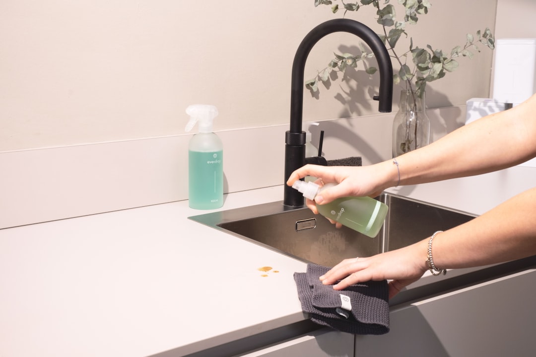 services-img a-woman-is-cleaning-a-kitchen-sink-with-a-rag-sqomdoqb3ws
